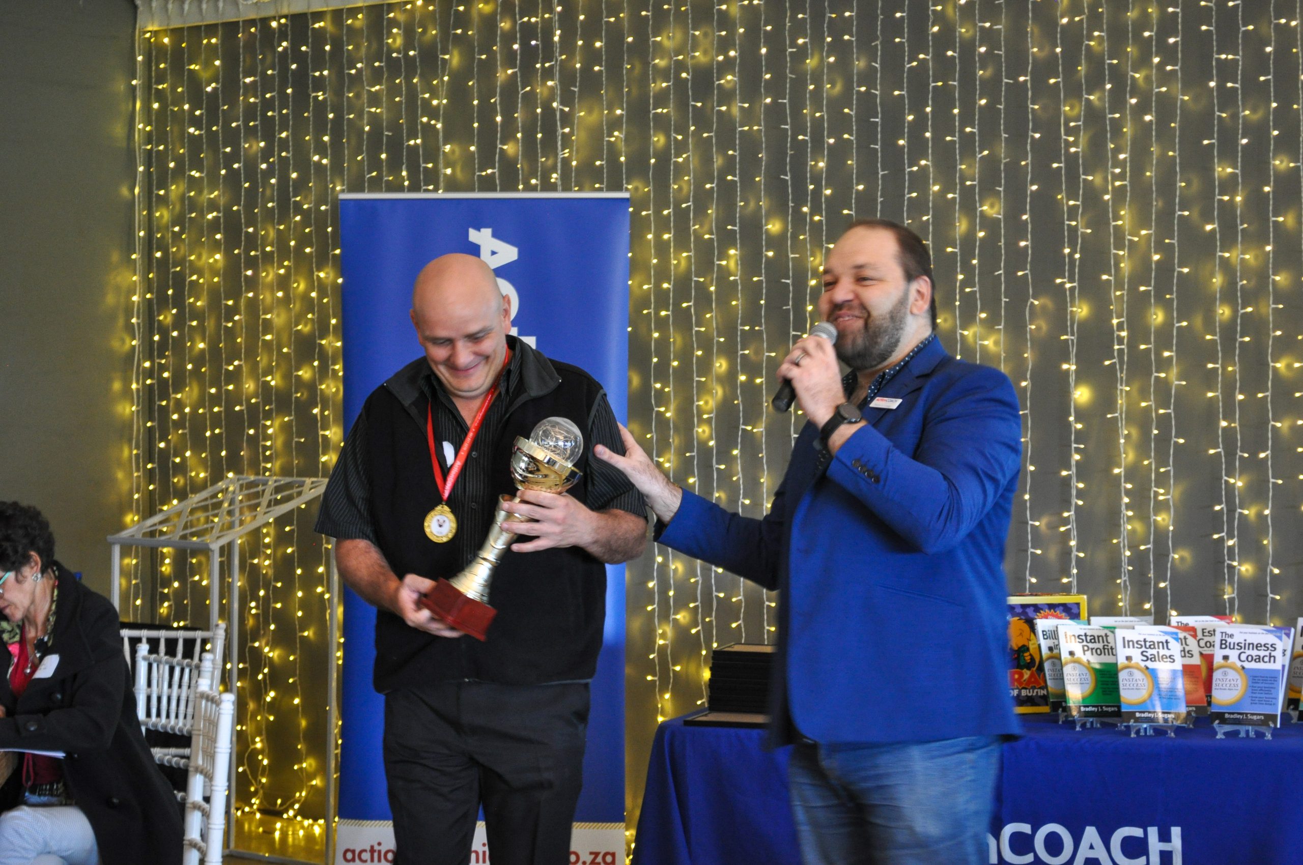 DSC_0890 An ActionCOACH awarding a business owner with a trophy.