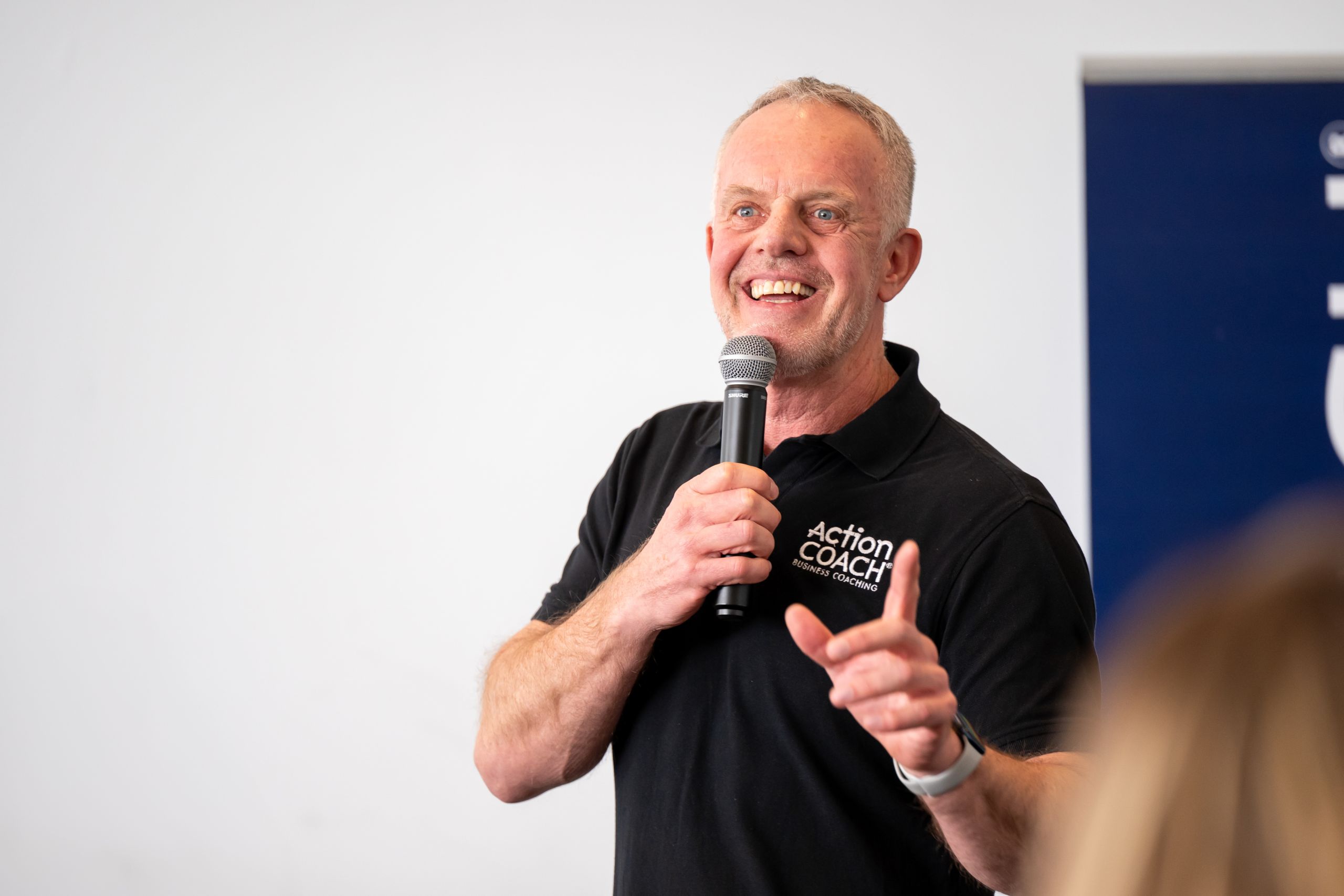 ActionCOACH Business Coach talking on a mic